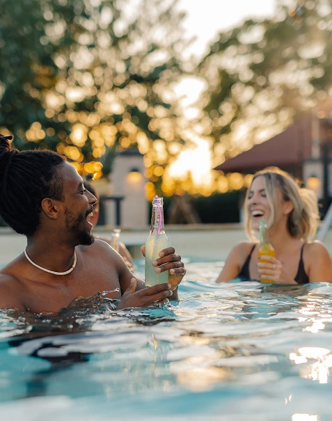 Friends socializing in a pool during golden hour
