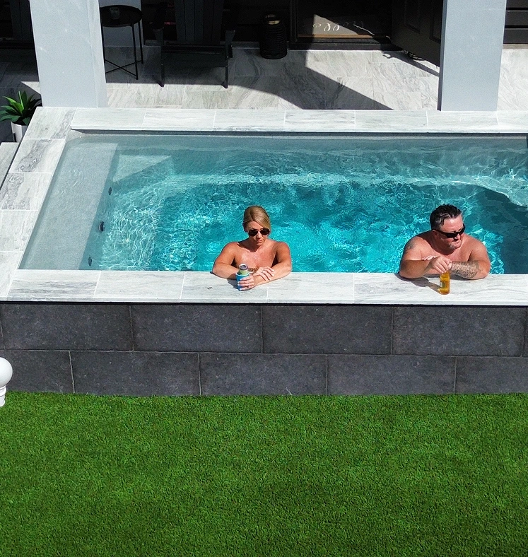 beautiful backyard with swimming pool and a couple chilling