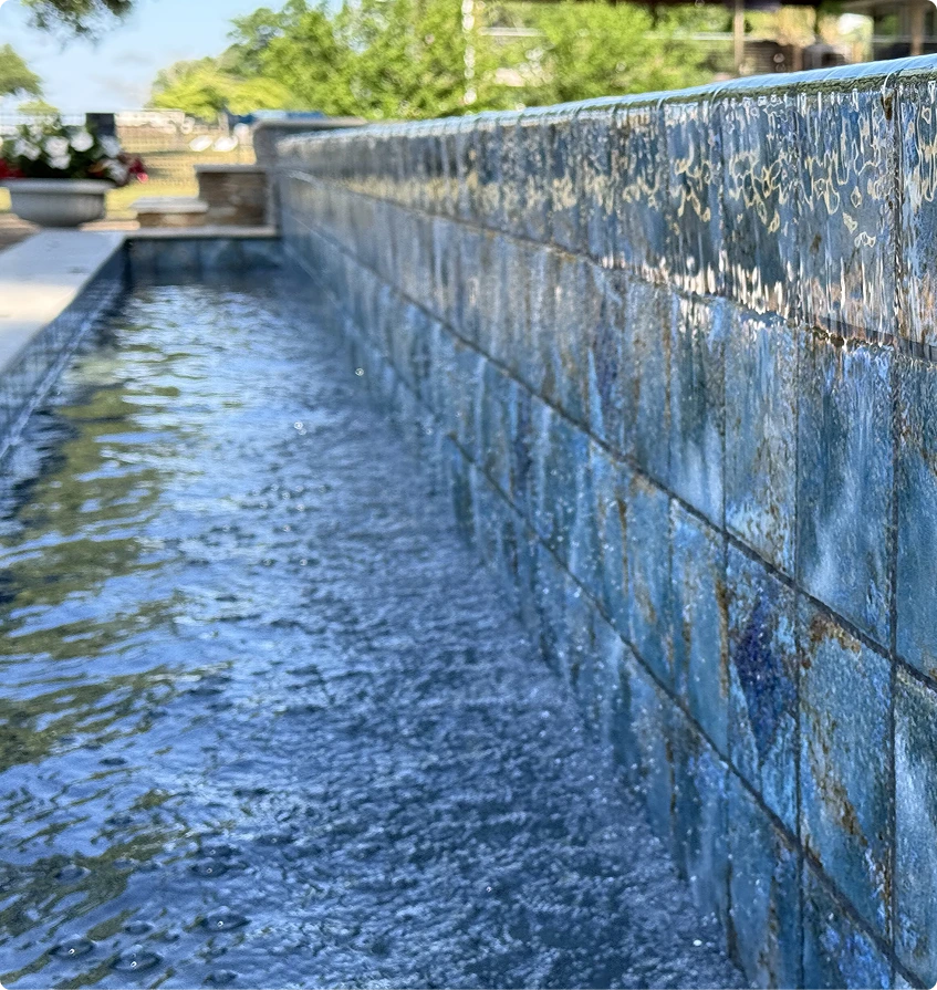 Blue tile infinity pool waterfall feature close up