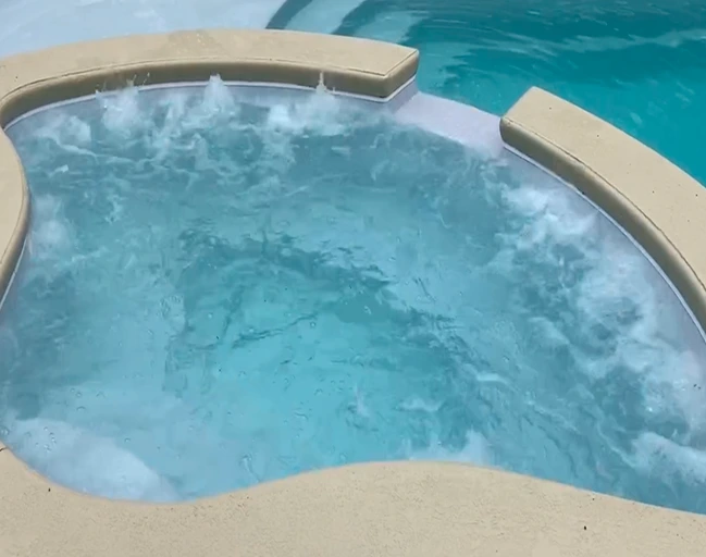 Bubbling spa hot tub connected to swimming pool