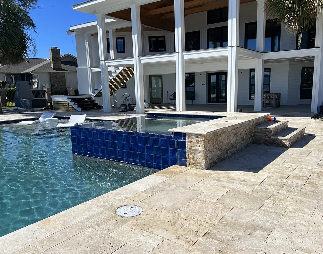 Luxury backyard pool and raised spa remodel with stone decking