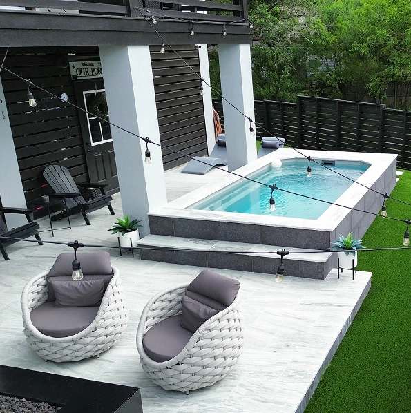 Modern outdoor plunge pool with tiled patio seating area