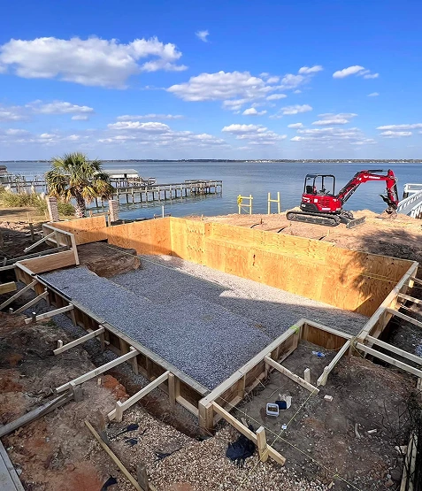 Waterfront backyard pool construction and excavation in progress